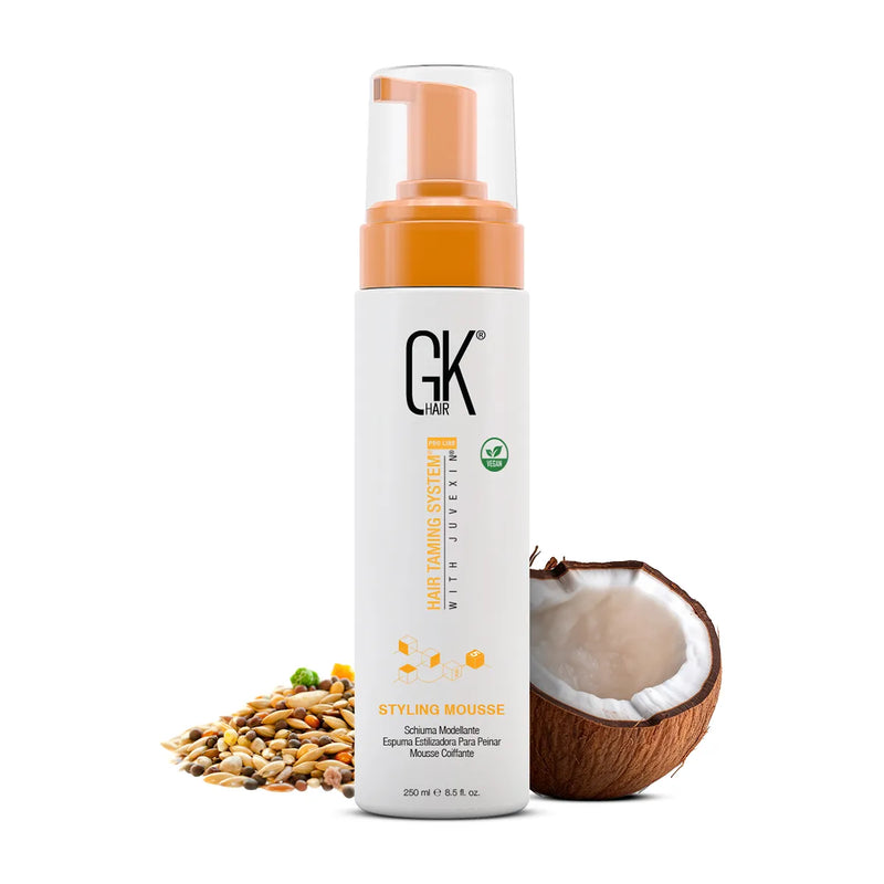 GK Hair Styling Mousse 250 ml white pump bottle with vegan badge, beside mixed seeds and half a coconut