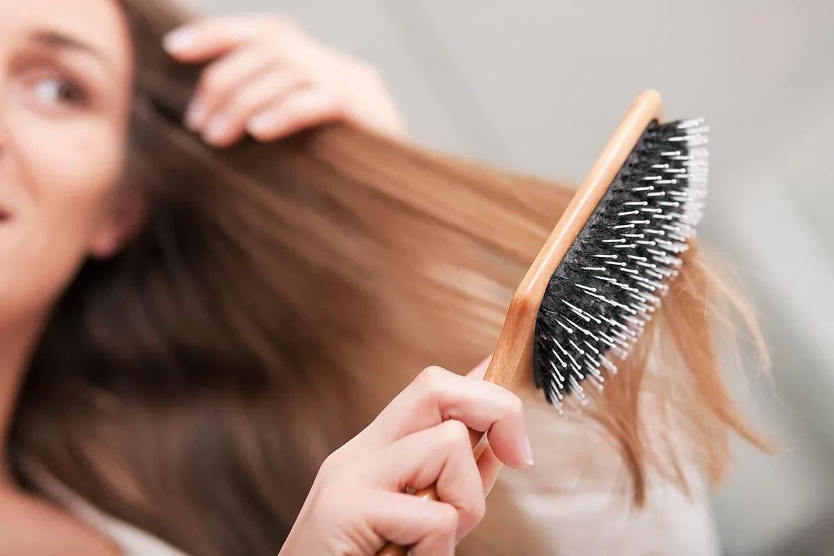 Woman rinsing shampoo from long wet hair in the shower