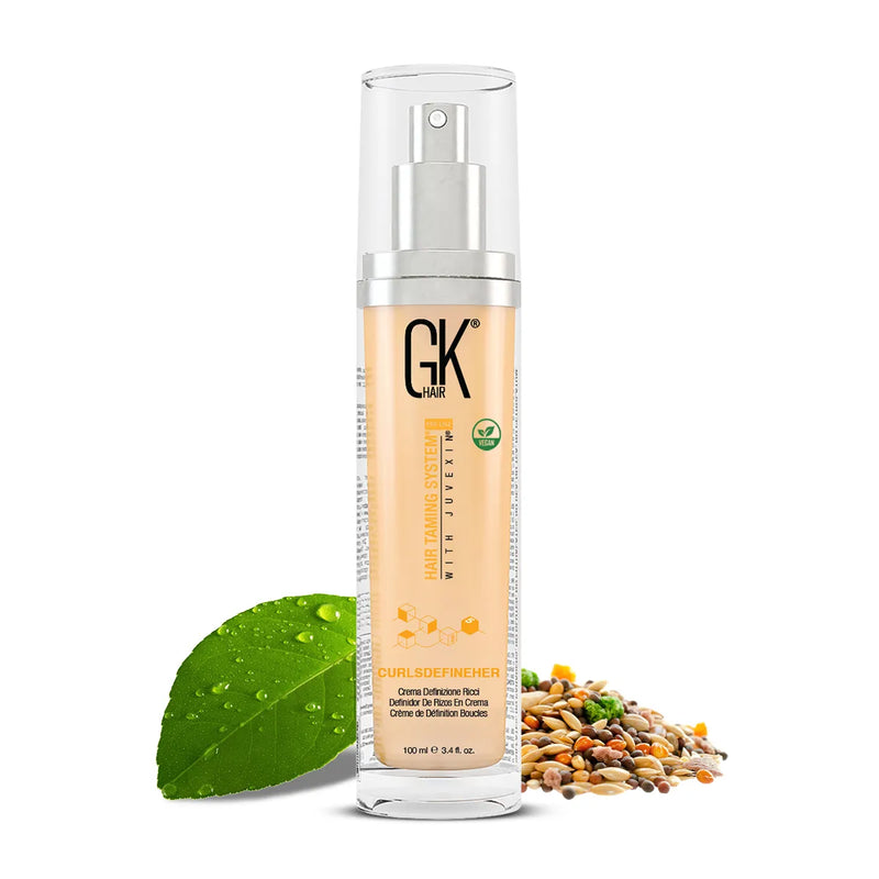 GK Hair CurlsDefineHer curl definition cream in a 100 ml pump bottle, beside a green leaf and a pile of seeds