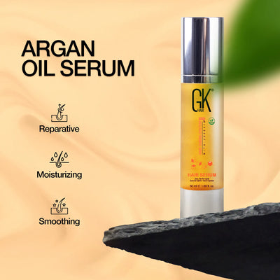 GK Hair Argan Oil Serum on a black rock, highlighting its reparative, moisturizing, and smoothing benefits for hair.