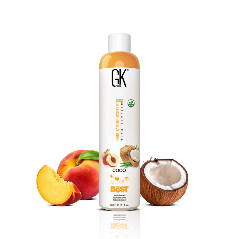 GK Hair's The Best Coco 300ml in-between a broken coconut and a whole apple alongside a sliced apple