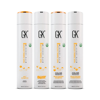 Four GK Hair products: pH+ Shampoo, Best Shampoo, Color Protection Moisturizing Shampoo, and Conditioner, all in sleek white packaging.